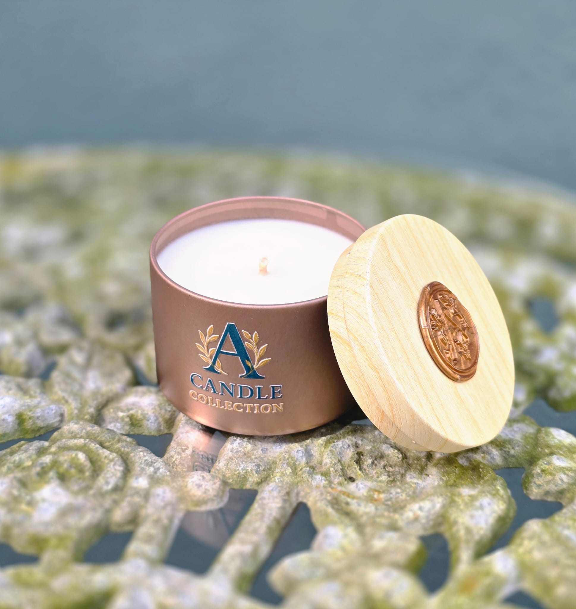 Świeca sojowa 90 g A Candle Collection w złotym metalowym pojemniku z pokrywką obok